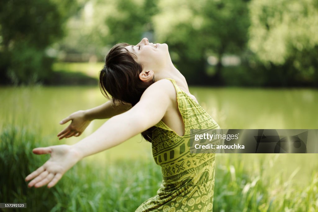 Junge Frau, die Ihr Gesicht nach oben und genießen Sie die Sonne