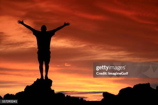 unrecognizable man in praise and worship silhouette - arms outstretched silhouette stock pictures, royalty-free photos & images