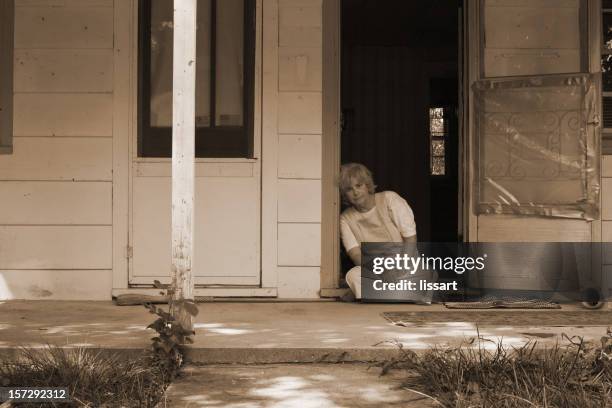 sepia picture of elderly woman sitting at the doorstep - depression land feature stock pictures, royalty-free photos & images