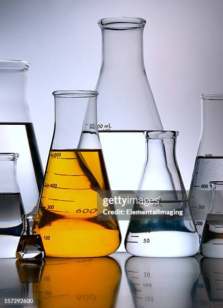 yellow flask amid group of erlenmeyers - boiling flask stock pictures, royalty-free photos & images