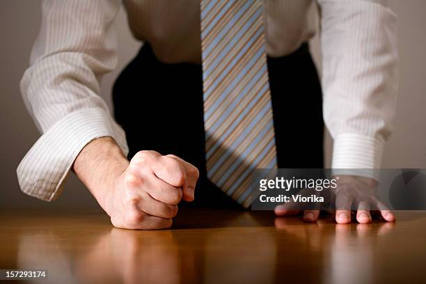close-up of a determined man with his fist on the table - raid stockfoto's en -beelden