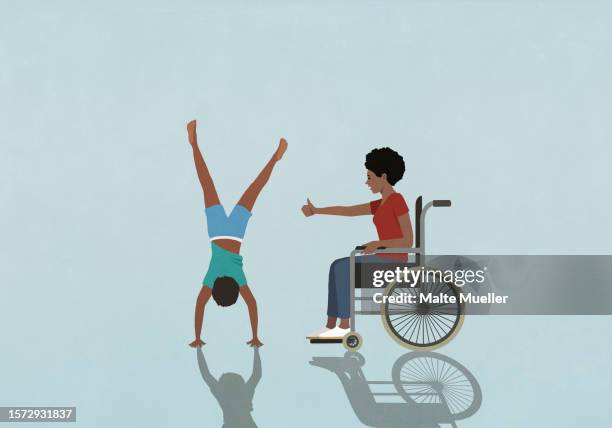 mother in wheelchair cheering for son doing handstand - accessibility stock illustrations