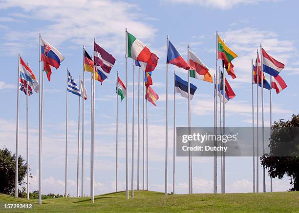 flags of the european union, in a circle, on tall flagpoles  - eu democracy stock pictures, royalty-free photos & images