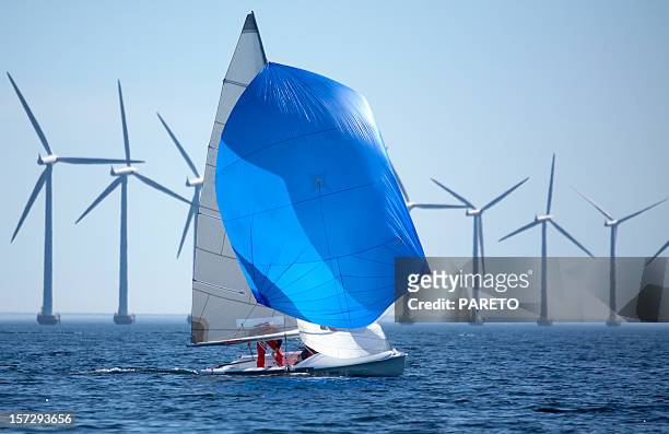 windmills and a sailboat in the middle of the sea - spinnaker stockfoto's en -beelden