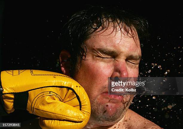 a stop-action photo of a boxing glove striking a man's face - punching stock pictures, royalty-free photos & images