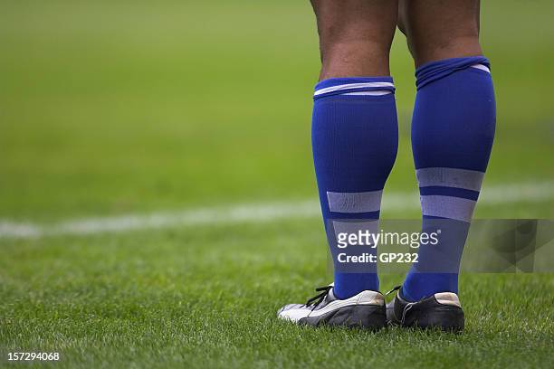 close up photo of rugby player's blue socks and white shoes - rugby league stockfoto's en -beelden