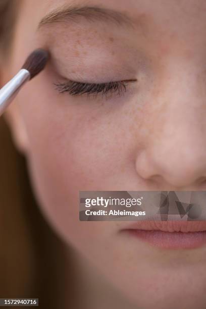 close up of young woman applying eye make-up with eyeshadow brush - eyelid fotografías e imágenes de stock