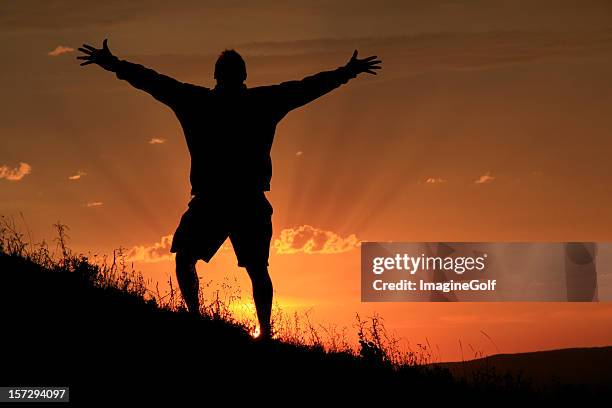 man celebrates climbing stop mountain - god is love stock pictures, royalty-free photos & images