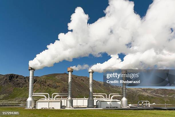 4 steel chimneys with smoke from geothermal energy - geothermische centrale stockfoto's en -beelden