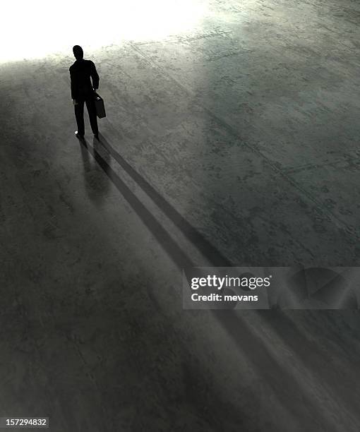 silhouetted image of man facing toward a bright future - long shadow shadow stock pictures, royalty-free photos & images