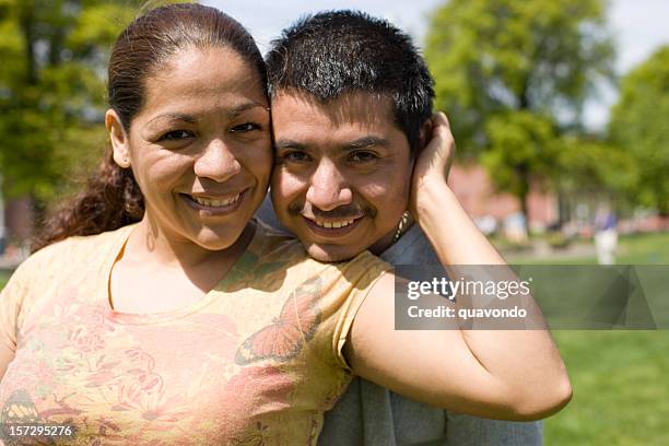 cheerful hispanic couple smiling portrait outside, copy space - 面貼面 個照片及圖片檔