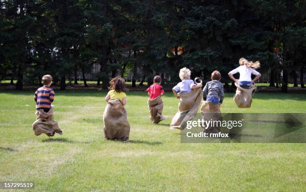 young children taking part in a sack race - sack race stock pictures, royalty-free photos & images