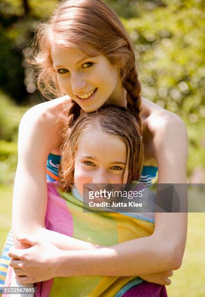 teen girl hugging sister and drying her off - due sorelle foto e immagini stock
