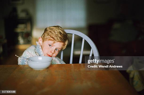 a young boy and his breakfast - wrapped in a blanket stockfoto's en -beelden