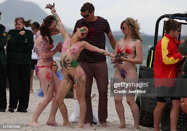 Girls in body paint ham it up with a local radio dj during an attempt to break the skinny dip world record at Papamoa Beach on December 2, 2012 in...