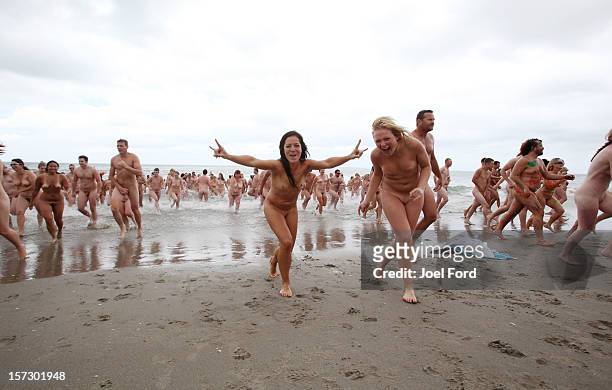 Pair of skinny dippers exit the water during an attempt to break the skinny dip world record at Papamoa Beach on December 2, 2012 in Tauranga, New...