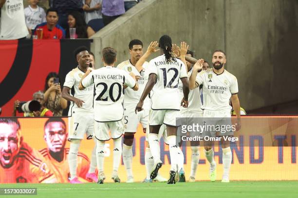 Jude Bellingham of Real Madrid celebrates with his teammates after scoring the opening goal during a friendly match between Real Madrid and...