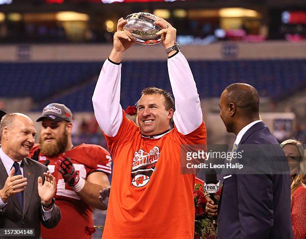 Wisconsin Badgers head coach Bret Bielema celebrates the Big Ten Championship holding the Amos Alonzo Stagg Championship Trophy after defeating the...