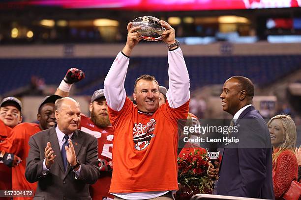 Wisconsin Badgers head coach Bret Bielema celebrates the Big Ten Championship holding the Amos Alonzo Stagg Championship Trophy after defeating the...
