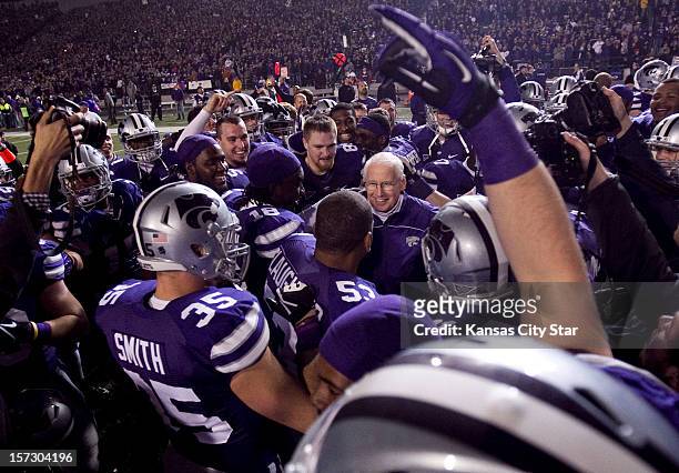 Kansas State head coach Bill Snyder is surrounded by players in celebration of their Big 12 Championship after a 42-24 win against Texas on Saturday,...