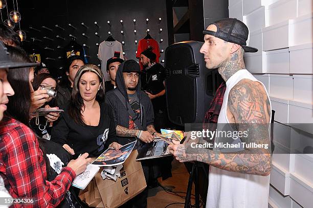 Blink-182 drummer Travis Barker signs autographs for fans at the launching of the One Life One Chance web store on December 1, 2012 in Los Angeles,...