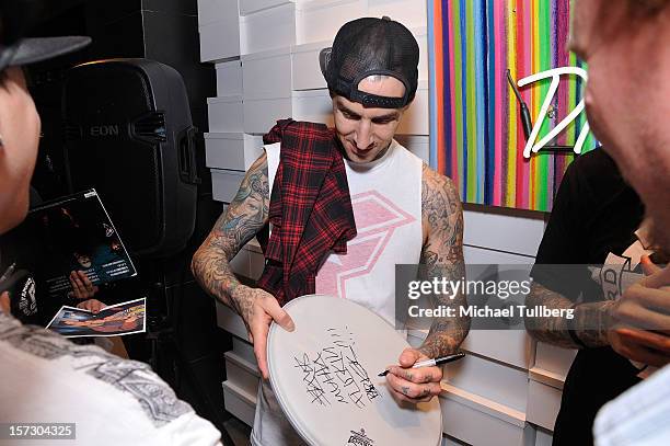 Blink-182 drummer Travis Barker signs autographs for fans at the launching of the One Life One Chance web store on December 1, 2012 in Los Angeles,...