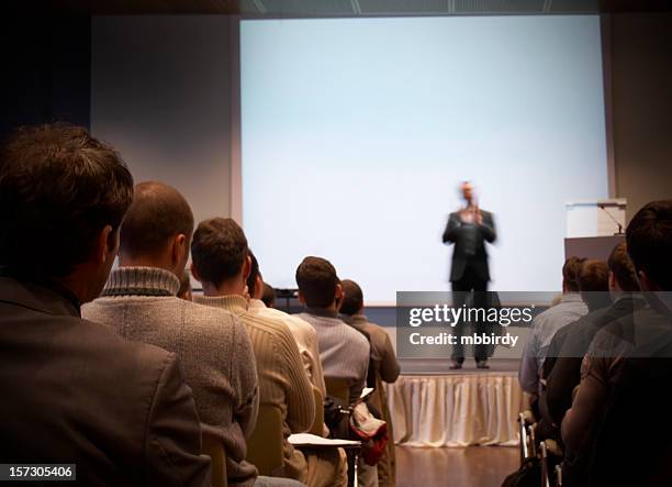 business conference in a hall with white screen - male presenter stock pictures, royalty-free photos & images