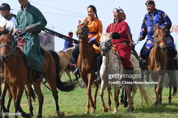 Participants with children ride horses during the Nadam Fair on July 26, 2023 in Xilingol League, Inner Mongolia Autonomous Region of China. An...