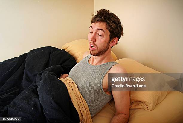 young adult struggles to wake up in the morning - hangover stockfoto's en -beelden