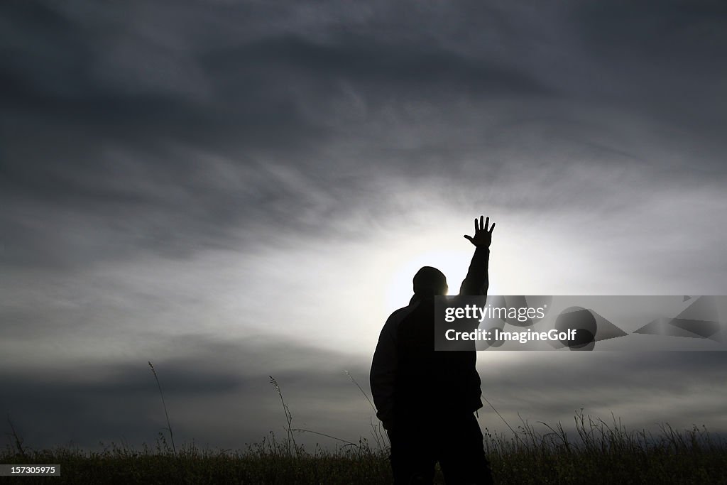 Silhueta de homem em preto e branco com mão fique em um culto