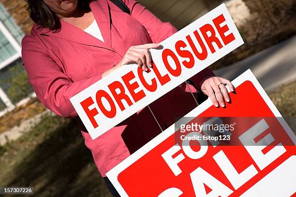 si raccomanda qualcuno mettendo up per vendita immobiliare segno con pignoramento - foreclosure foto e immagini stock
