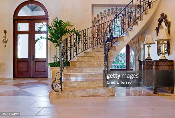 beautiful entryway with custom wrought iron staircase in estate home - iron railings stock pictures, royalty-free photos & images