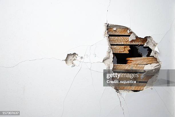 cracked plaster, drywall and wood of a home's white wall - gat stockfoto's en -beelden