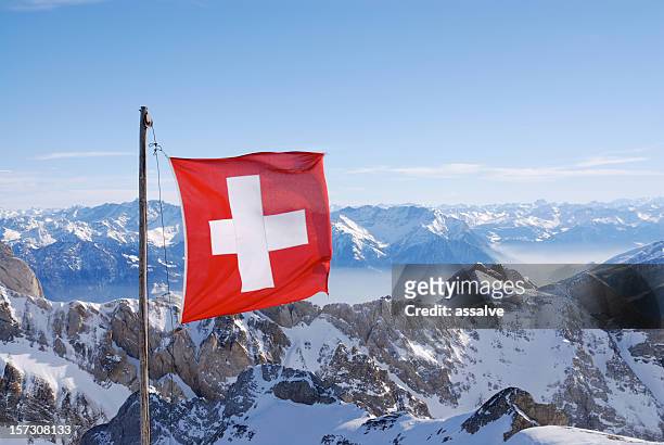 swiss flag flying over snowy mountains - swiss flag bildbanksfoton och bilder