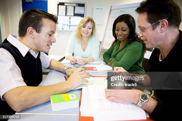 adult education: mature students working together in the classroom - teacher meeting stock pictures, royalty-free photos & images