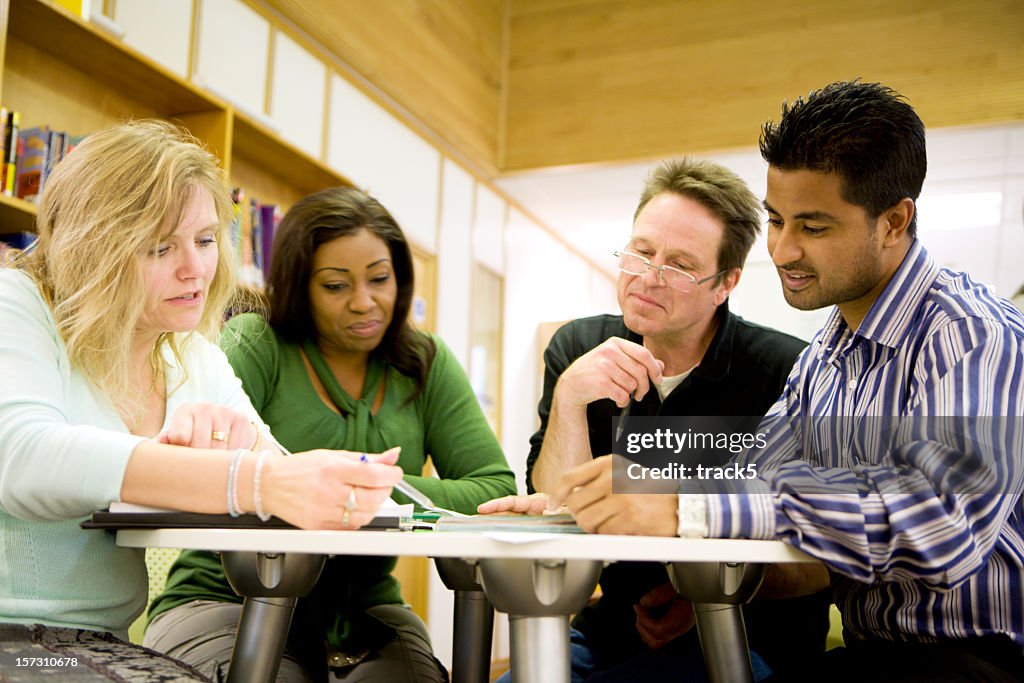 Adult education: Diverse mature students working in their college library