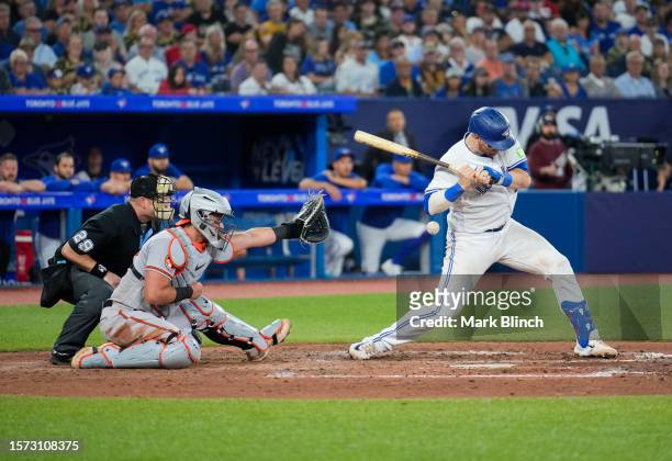 Danny Jansen of the Toronto Blue Jays gets hit by a pitch with the bases loaded against the Baltimore Orioles during the sixth inning in their MLB...