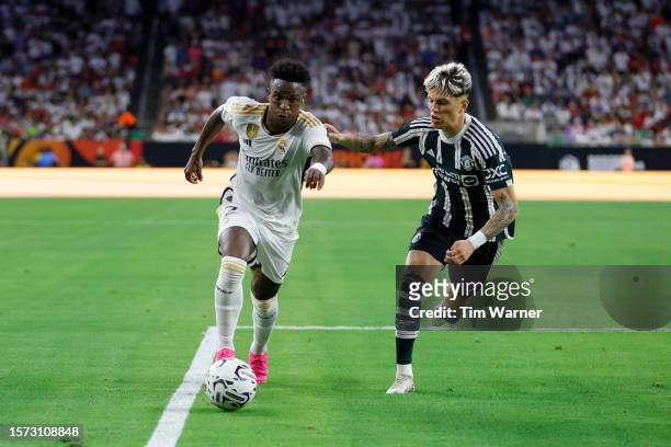 Vinicius Júnior of Real Madrid dribbles the ball defended by Alejandro Garnacho of Manchester United in the first half during the 2023 Soccer...