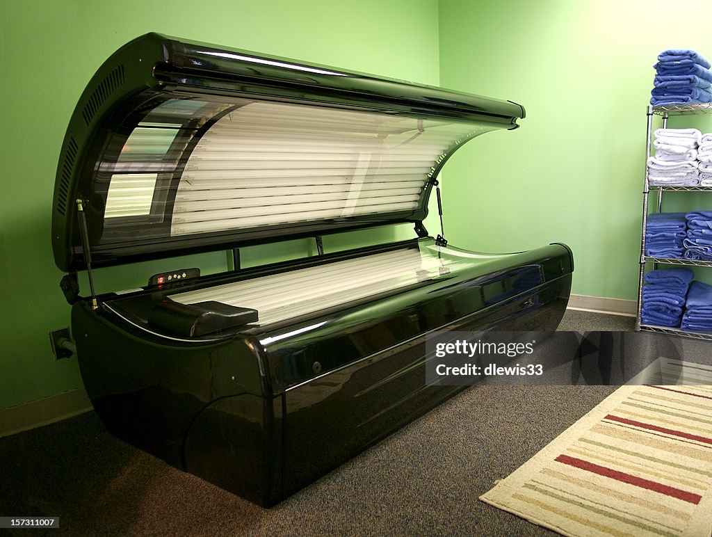 An open tanning bed in a green room