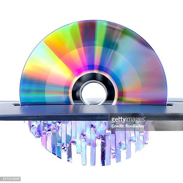 metal cd of reflecting colors gets shredded through cutter - paper shredder on white stock pictures, royalty-free photos & images