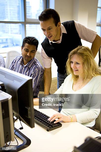 adult education: office colleagues working together at the computer - computer training stock pictures, royalty-free photos & images