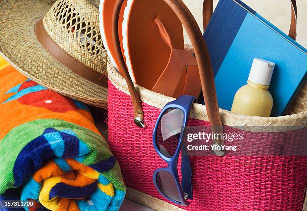 summer beach bag with suntan lotion, towel, sunglasses, hat - beach bag stockfoto's en -beelden