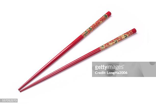 two red chopsticks on a white background - eetstokje stockfoto's en -beelden