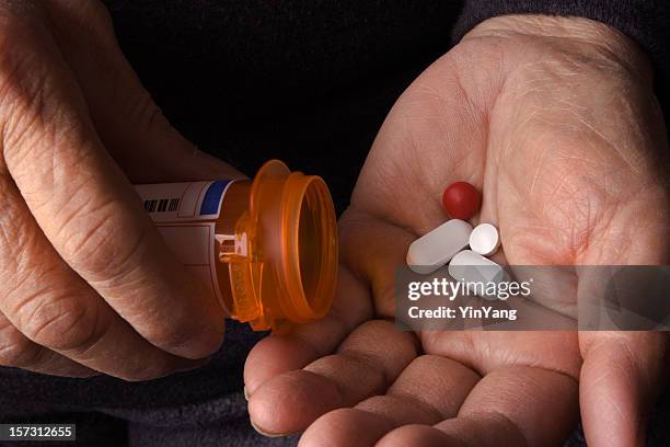 senior adulte mains avec prescription des médicaments de médecine drogues capsule - hand holding several pills photos et images de collection