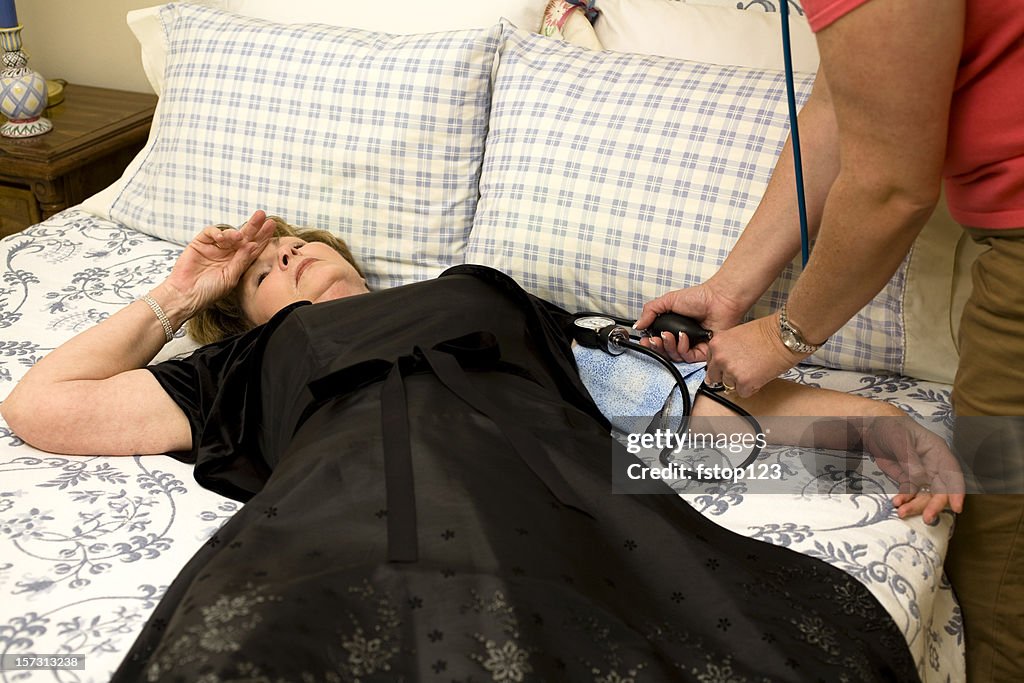 Mature woman lying bed. Fainted. Blood pressure gauge. Healthcare. Medical.