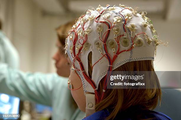 girl connected with cables for eeg for a scientific experiment - children in a lab stock pictures, royalty-free photos & images