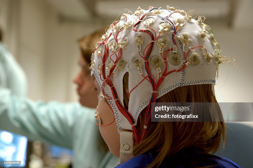 Girl connected with cables for EEG for a scientific experiment