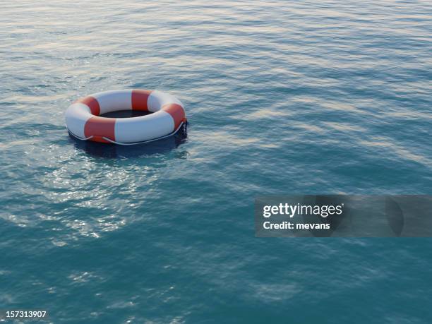 life buoy floating on a rippled sea - rescue stock pictures, royalty-free photos & images