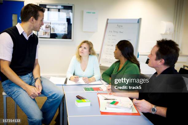 adult education: class study with mature learners - teacher with folder stock pictures, royalty-free photos & images