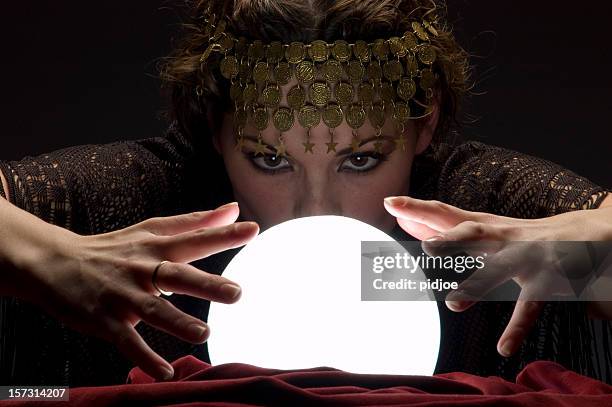 fortune teller with glowing crystal ball - crystal ball stock pictures, royalty-free photos & images